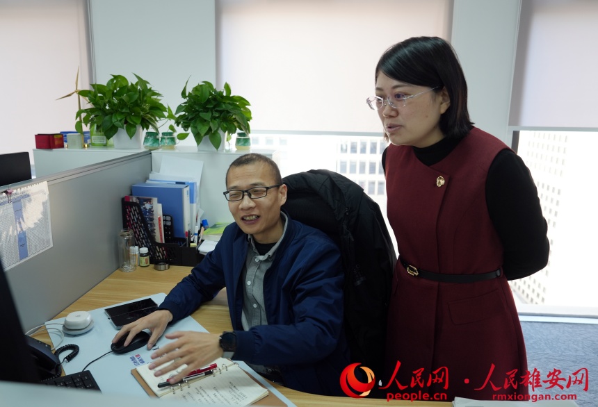 王丽杰（右）和同事进行项目交流。人民网记者 杨文娟摄